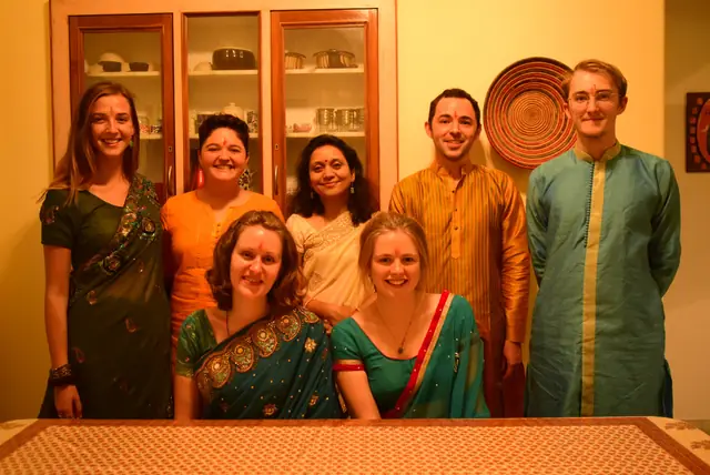 Guests dressed in saris and kurtas in a family living room before an evening out