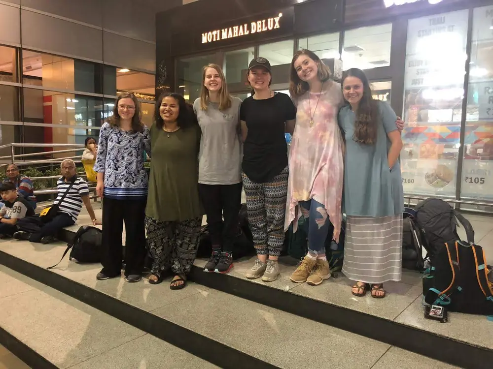 A travelling group on the steps outside a Delhi restaurant in the evening