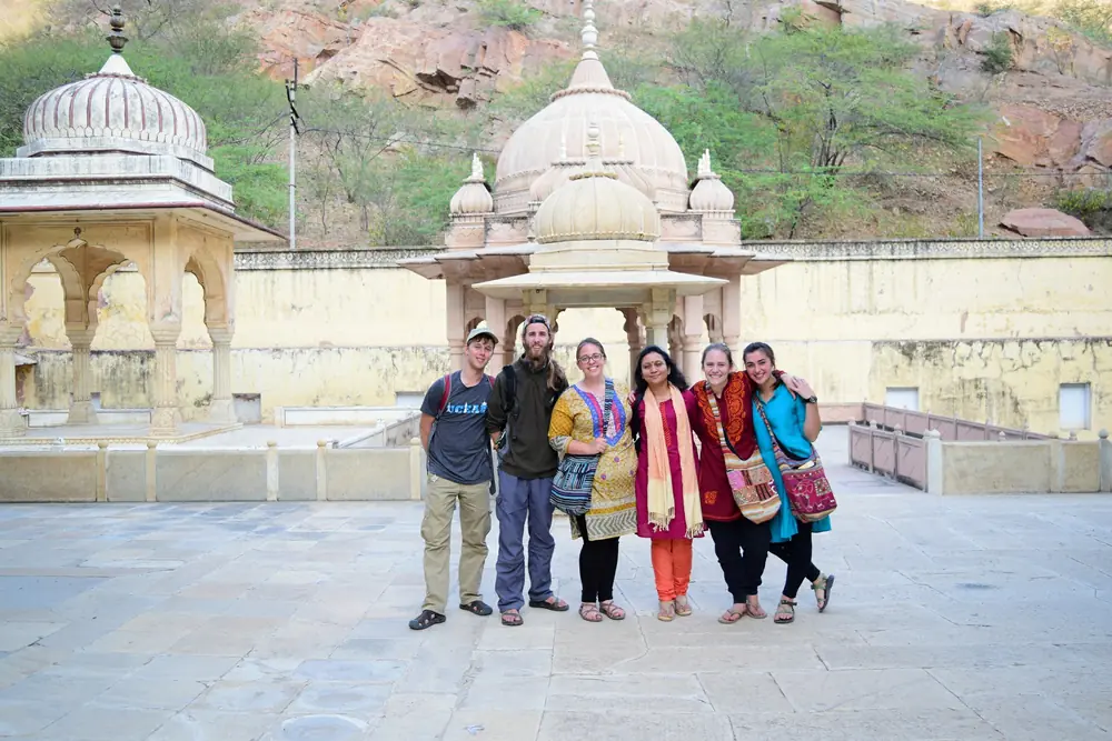 Domed cenotaphs on a walled terrace below a rocky hillside