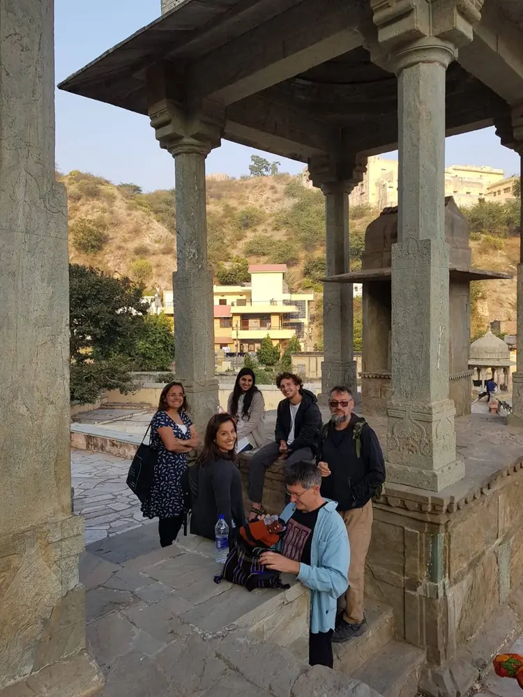 The group resting under a stone pavilion above the town