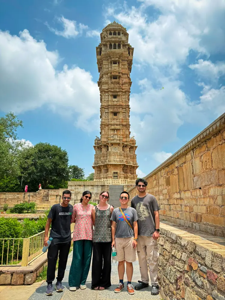 A group below the carved Tower of Victory at Chittorgarh Fort