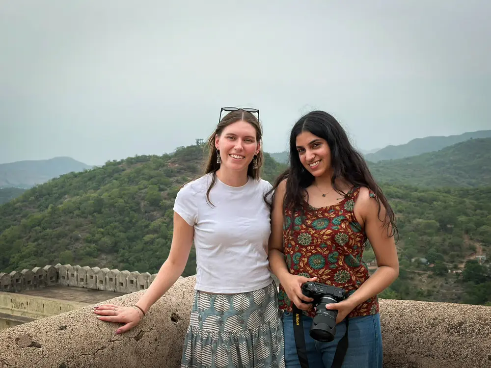 Two travellers on a fort rampart with green hills stretching behind