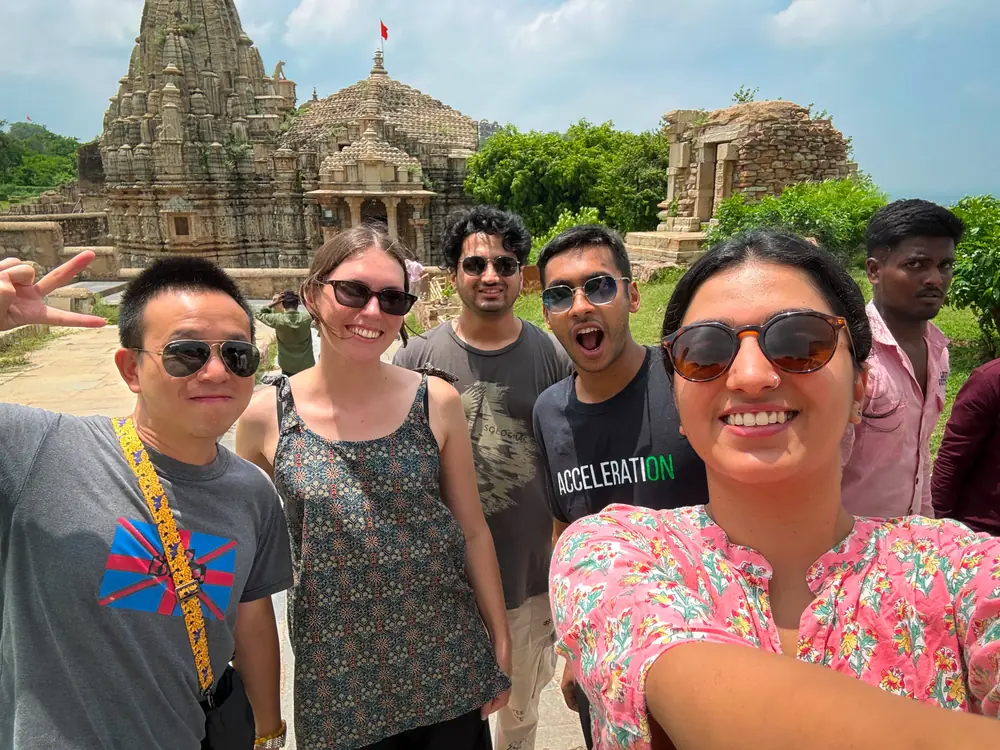 The group crowded into a photograph outside a carved stone temple