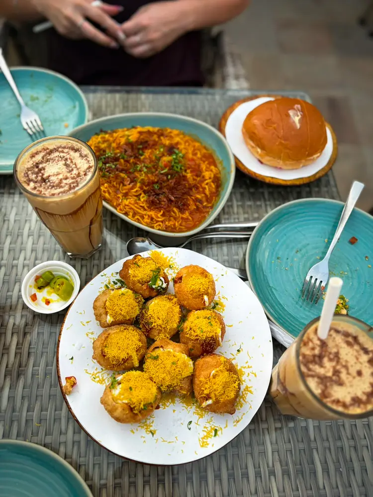 A table of Rajasthani snacks and coffee on a wet monsoon afternoon